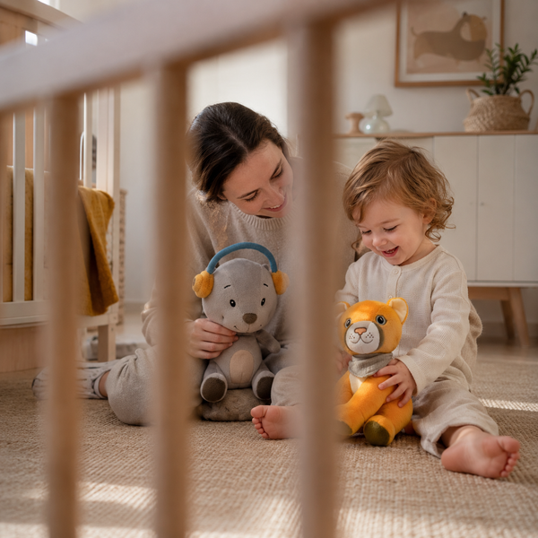 Kleinkind spielt mit Mutter und den Lenabies Aaron dem Bären und Tali der Puma Dame im hellen Kinderzimmer. Interaktive Kuscheltiere für Kinder fördern Fantasie, Geschichten und spielerisches Lernen.