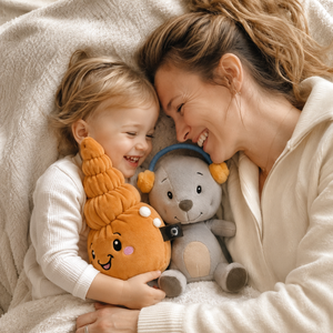 Kleinkind kuschelt gemeinsam mit seiner Mutter und den Lenabies Aaron dem Bären und Mia der Muschel auf einer weichen Decke. Die interaktiven Kuscheltiere begleiten liebevolle Familienmomente voller Geborgenheit, Fantasie und Nähe.
