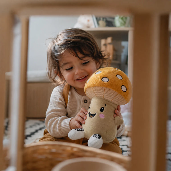 Kind spielt im Kinderzimmer mit Lenabie Felix dem Pilz, einem interaktiven Audio-Kuscheltier für Kinder. Das smarte Kuscheltier begleitet Kinder mit Hörspielen, Kindergeschichten und Musik und fördert kreatives Spielen sowie fantasievolle Entdeckungsmomente.